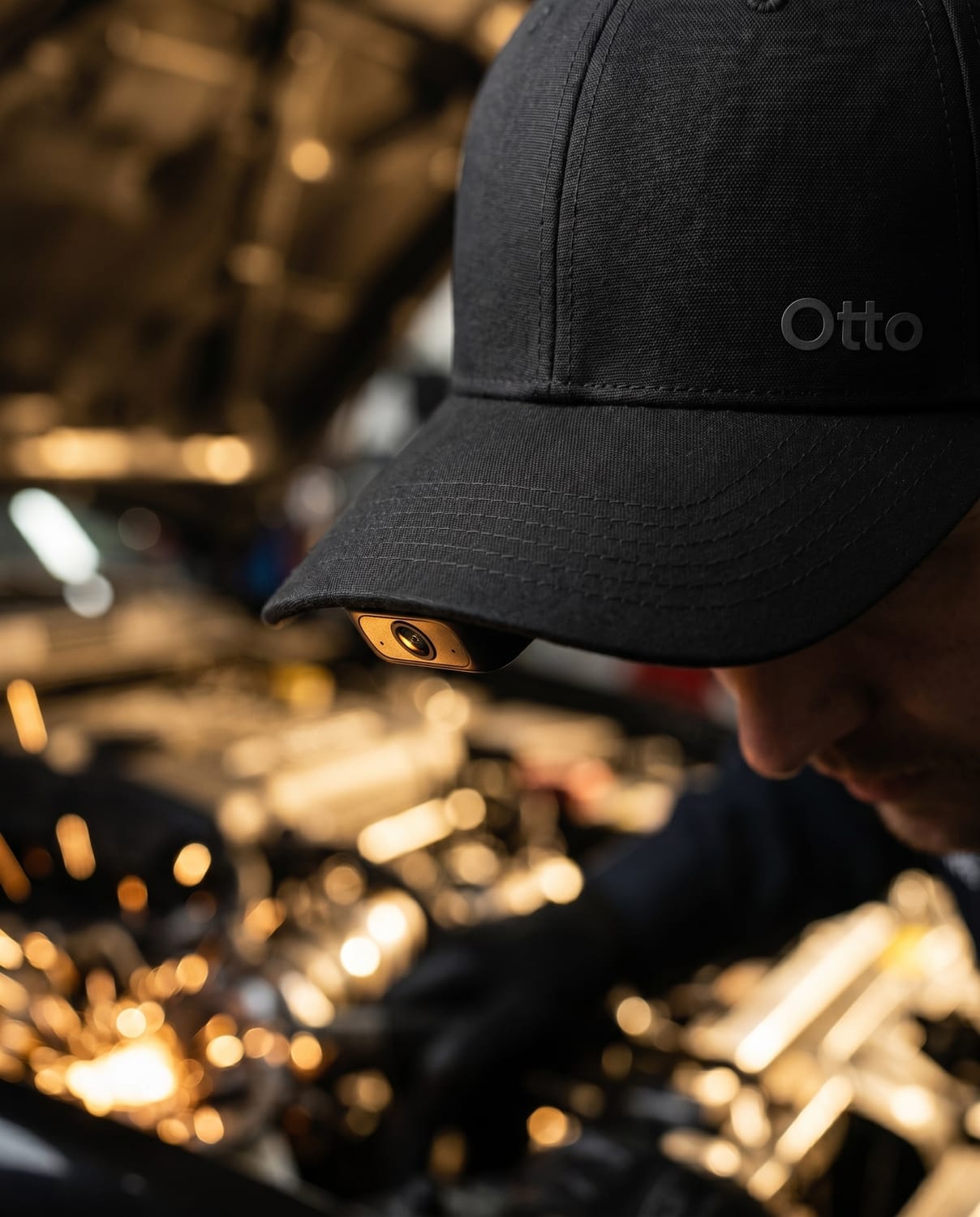 A mechanic wearing the Otto cap, the under-brim camera looking into an engine bay