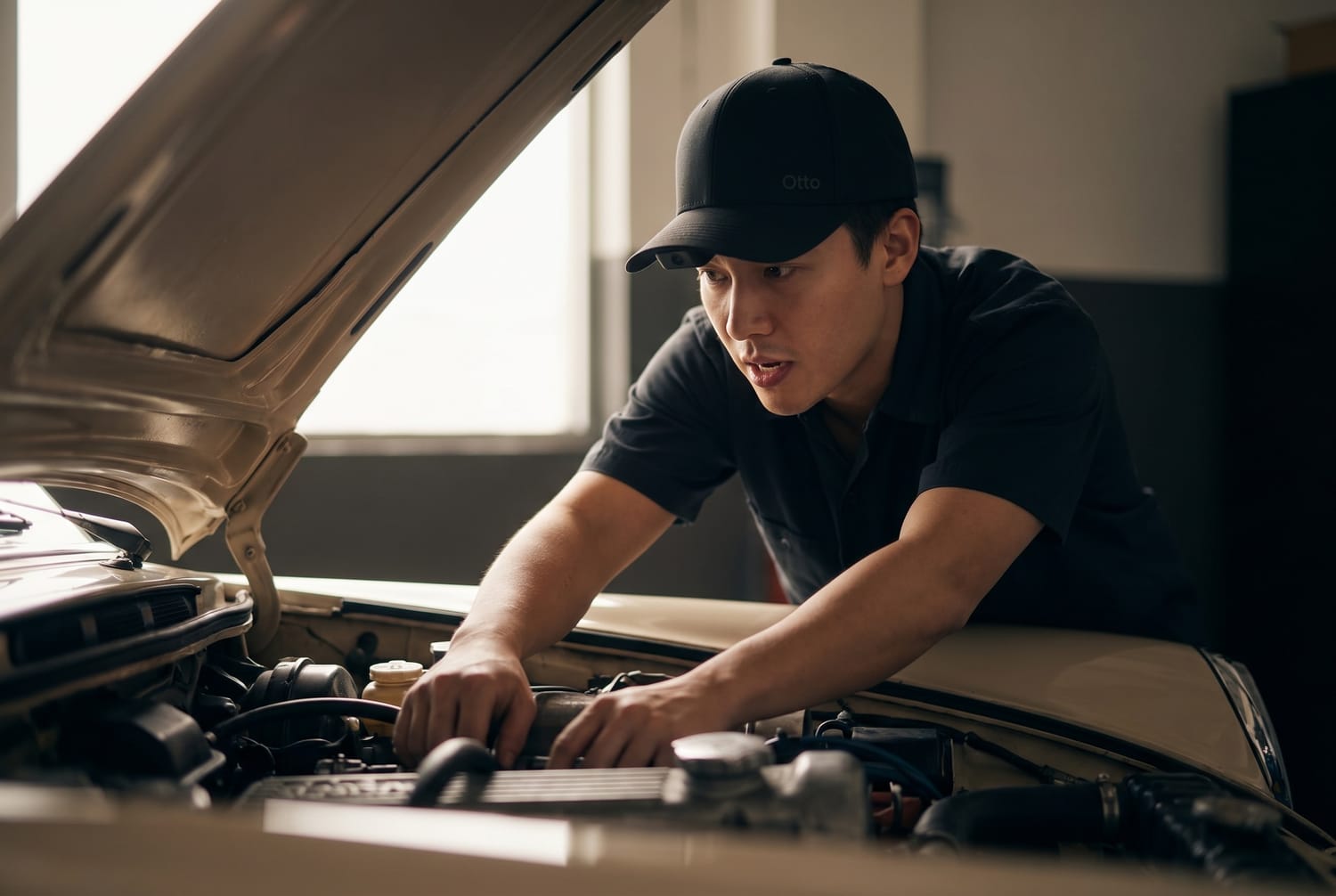 A mechanic wearing the Otto cap, leaning over an engine bay